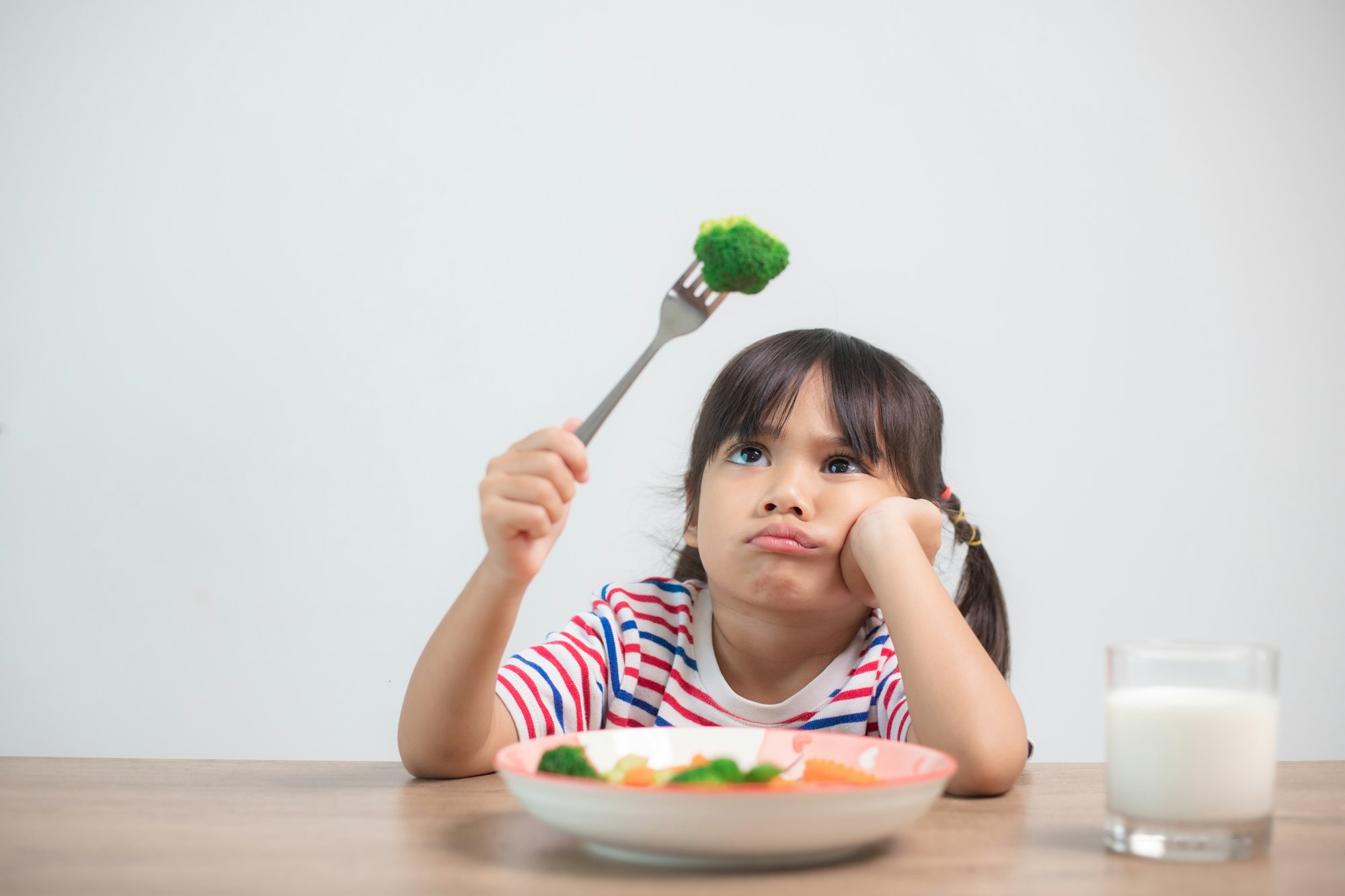 Nutrition & healthy eating habits for kids concept. Children do not like to eat vegetables.